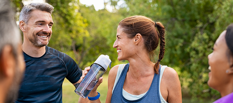 Group of adults with water bottle, exercising and smiling.